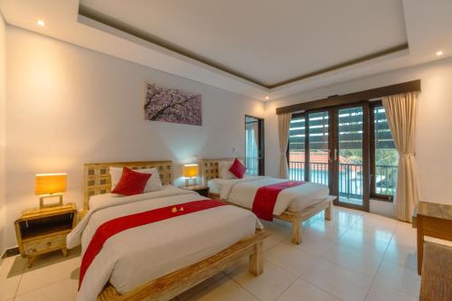 a bedroom with two beds and a large window at Villa Raka by Manara in Legian