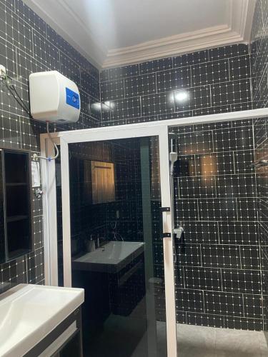 a bathroom with a black tiled wall with a sink at Excel Roses Hotels in Kontrajeso