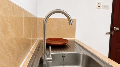 a kitchen sink with a copper bowl in it at Rabbit Mansion Patong Hotel in Patong Beach