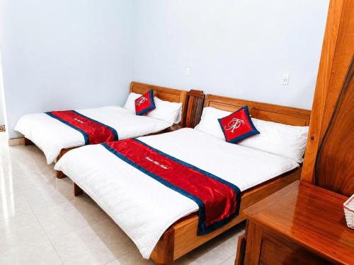 two beds in a room with red and white at Thiên Phúc Hotel in Mộc Châu