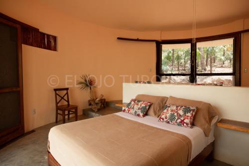 a bedroom with a bed and a window at Cabañas Cascadas Mágicas in San Miguel del Puerto