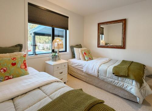 a bedroom with two beds and a mirror at The Highland - Sunset Ridge in Ruatapu