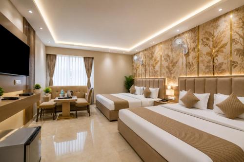 a hotel room with two beds and a television at Hotel Kelvish Plaza-Delhi Airport in New Delhi