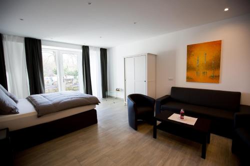 ein Wohnzimmer mit einem Bett und einem Sofa in der Unterkunft Wassersport-Appartements am Stößensee in Berlin