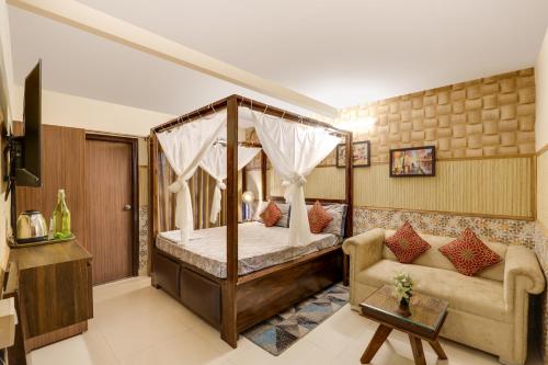 a bedroom with a canopy bed and a couch at House Of Comfort Greater Noida in Greater Noida