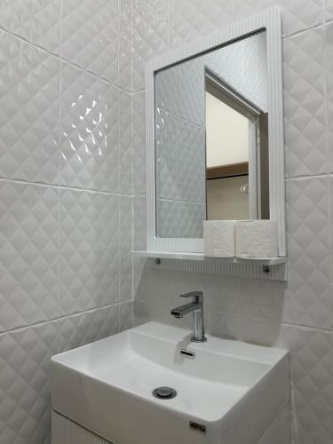 a white bathroom with a sink and a mirror at The Summer Cozy Cottage 2 in Haad Chao Phao