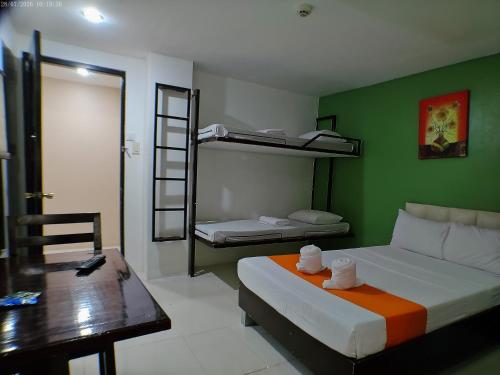 a room with a bed and a desk and bunk beds at StayLite in Tagbilaran City