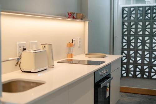 a kitchen with a sink and a toaster on a counter at BlackBrick Gardens in Cape Town
