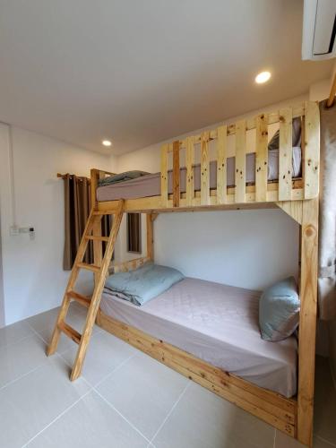 a bunk bed in a room with a ladder at Kan Haven Homestay in Kanchanaburi City