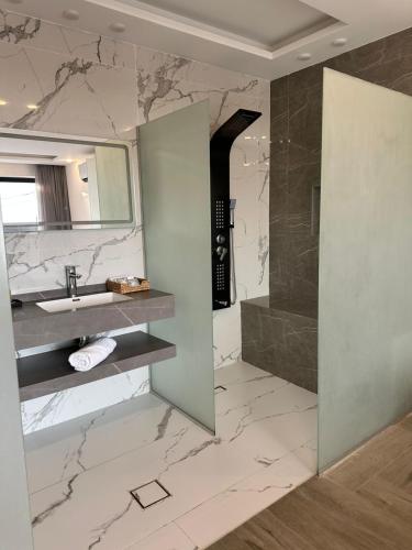 a bathroom with a sink and a shower and a mirror at Madrid Luxury Villa in Al Rama