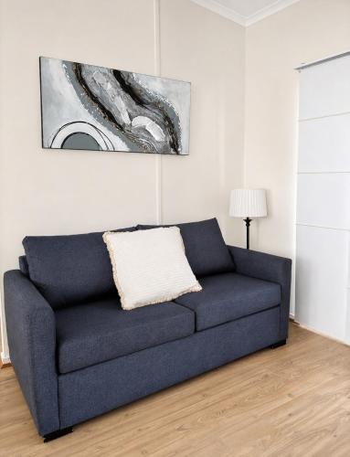 a blue couch in a living room with a painting at Badgee Park in Sussex Inlet