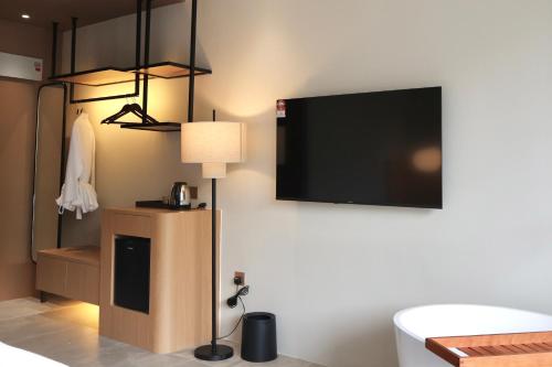 a room with a flat screen tv on a wall at By The Hill in Bukit Mertajam
