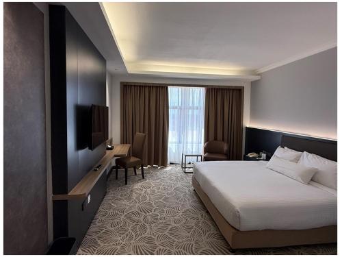 a hotel room with a bed and a television at Grand Riverview Hotel in Kota Bharu