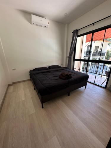 a bedroom with a bed and a large window at The Summer Cozy Cottage in Haad Chao Phao