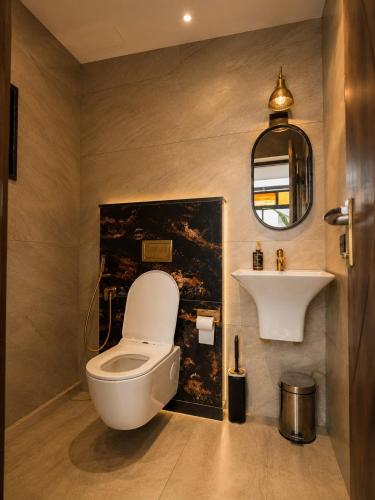 a bathroom with a toilet and a sink at Lofterra Luxury Apartment in Kozhikode city, calicut in Kozhikode