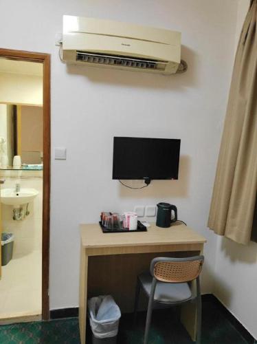 a room with a desk with a monitor and a chair at Man Va Hotel in Macau