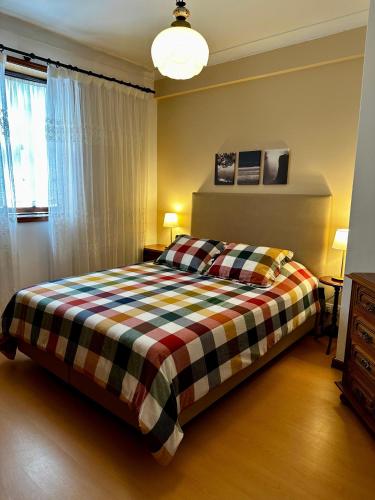 a bedroom with a bed with a checkered blanket at Central Home Arouca in Arouca