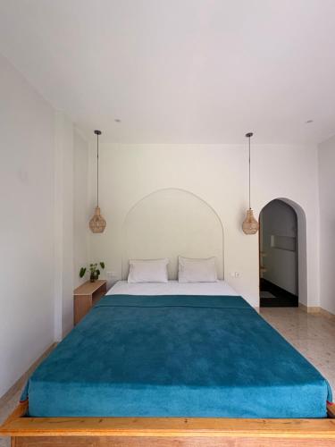 ein Schlafzimmer mit einem großen Bett und einer blauen Decke in der Unterkunft Rinjani Houseboon in Senaru
