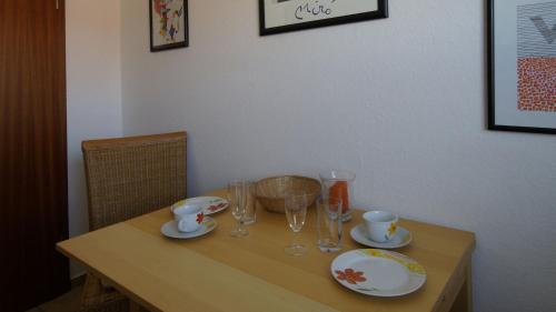 a wooden table with glasses and plates on it at Dümmer Refugium - Ferienwohnung in Lembruch
