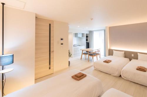 a hotel room with two beds and a table at ReLA Minami-Nagareyama in Nagareyama