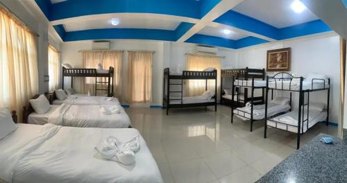 a bedroom with four beds and a blue ceiling at Nassim Hotel and Beach Resort in Casagan