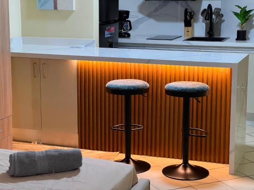 a kitchen with two bar stools in front of a counter at Exclusiva suite en Hotel Marbellamar in Pampatar