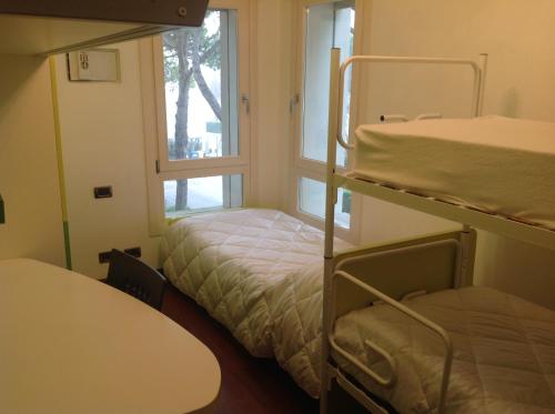 two bunk beds in a room with a window at Appartamento Sile in Cavallino-Treporti