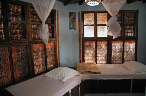 a bedroom with two beds and a window at Fromager in Cap Skirring