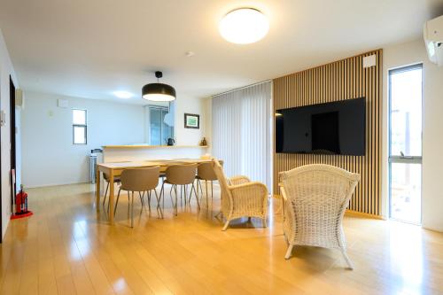 a living room with a dining room table and chairs at Villa UMMINA in Tahara