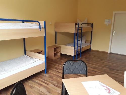 a room with bunk beds and a table and a chair at Internationales Gästehaus in Jena