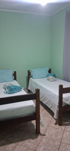 two twin beds in a room withthritisthritislictslictslicts at Pousada Bela Vista Santo Antônio do Manhuaçu in Caratinga