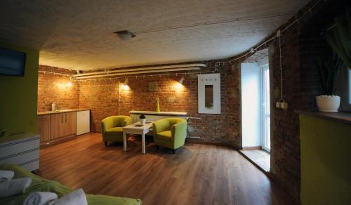 a living room with a table and two green chairs at Hostel Centrum in Września