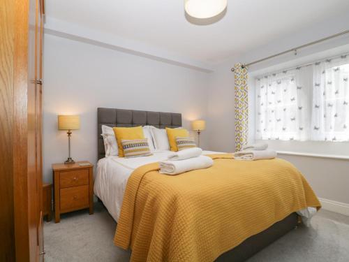 a bedroom with a large bed with a yellow blanket at High Spy in Keswick