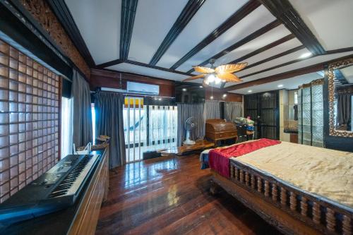 a bedroom with a large bed and a piano at Crystal Sea Villa in Ko Larn