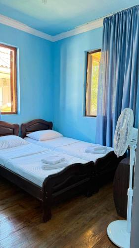 a bedroom with a large bed with blue walls at Sea Breeze House Ureki in Ozurgetʼi