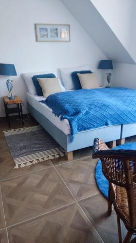 a bedroom with a bed with a blue comforter at Gryfon Dom in Jastarnia