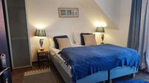 a bedroom with a bed with a blue comforter at Gryfon Dom in Jastarnia