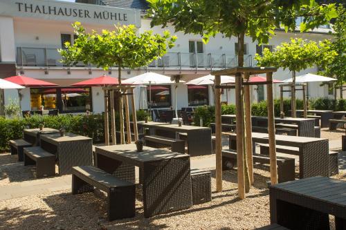 a group of tables and benches in front of a building at Thalhauser Mühle Hotel-Restaurant in Thalhausen