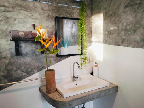 a bathroom with a sink and a vase with flowers at The Verandas in Hinkong