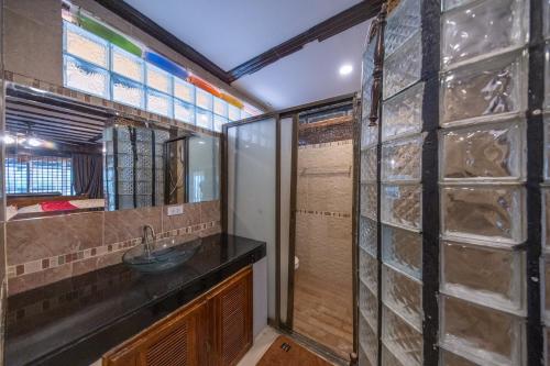 a bathroom with a sink and a glass wall at Crystal Sea Villa in Ko Larn