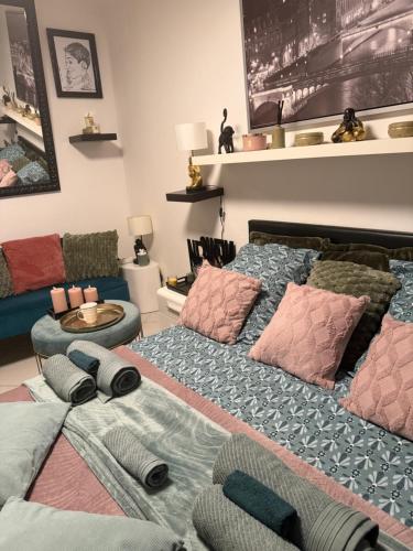 a bedroom with a bed with pillows and a couch at CHAMBRE dans appartement moderne guest house in Menton