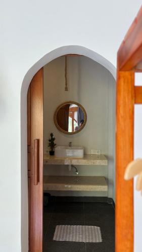 ein Badezimmer mit Waschbecken und Spiegel in der Unterkunft Rinjani Houseboon in Senaru