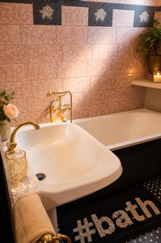 a bathroom with a white sink and a tub at Apartment Baci in Rose resort in Ljubljana
