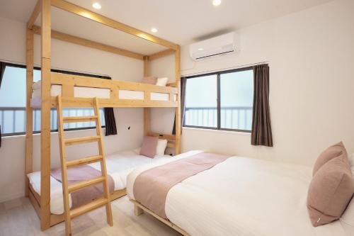 a bedroom with two bunk beds and a ladder at ぷにるんパーク in Nagoya