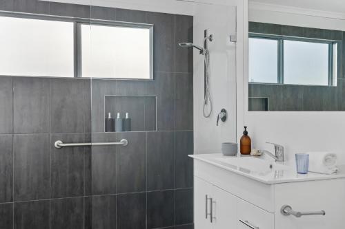 a bathroom with a shower and a sink and a mirror at Native Retreat - Tranquil Seaham Escape in Seaham