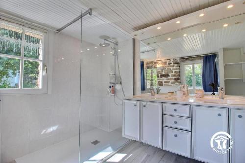 a white bathroom with a shower and a sink at Ty venoux in Elven