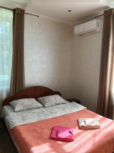 a bedroom with a bed with two towels on it at Панський Двір in Neslukhov