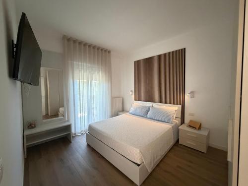 a bedroom with a bed and a flat screen tv at Dimore Capirro Charming Family House in Trani