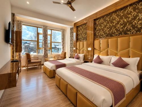 a hotel room with two beds and a television at Gulmarg Gul Sitara Resorts in Gulmarg