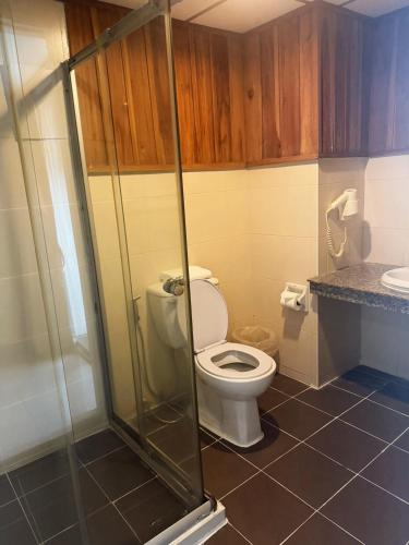 a bathroom with a toilet and a glass shower at The Spring Bangkok in Bangna